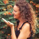 Smily practitioner in front of a flowery bush