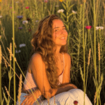 War smile, flowery meadow. Shakti Devi bathing in sunlight.