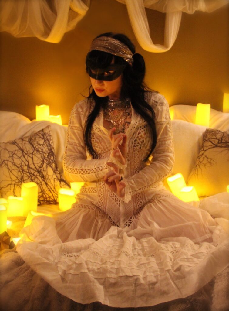 Kat V in a white dress surrounded by lights