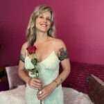 Lila Rose in a white dress holding a red rose.