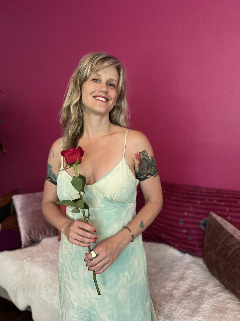 Lila Rose in a white dress holding a red rose.