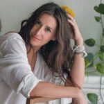 Relaxed Natalie sitting in a white dress.