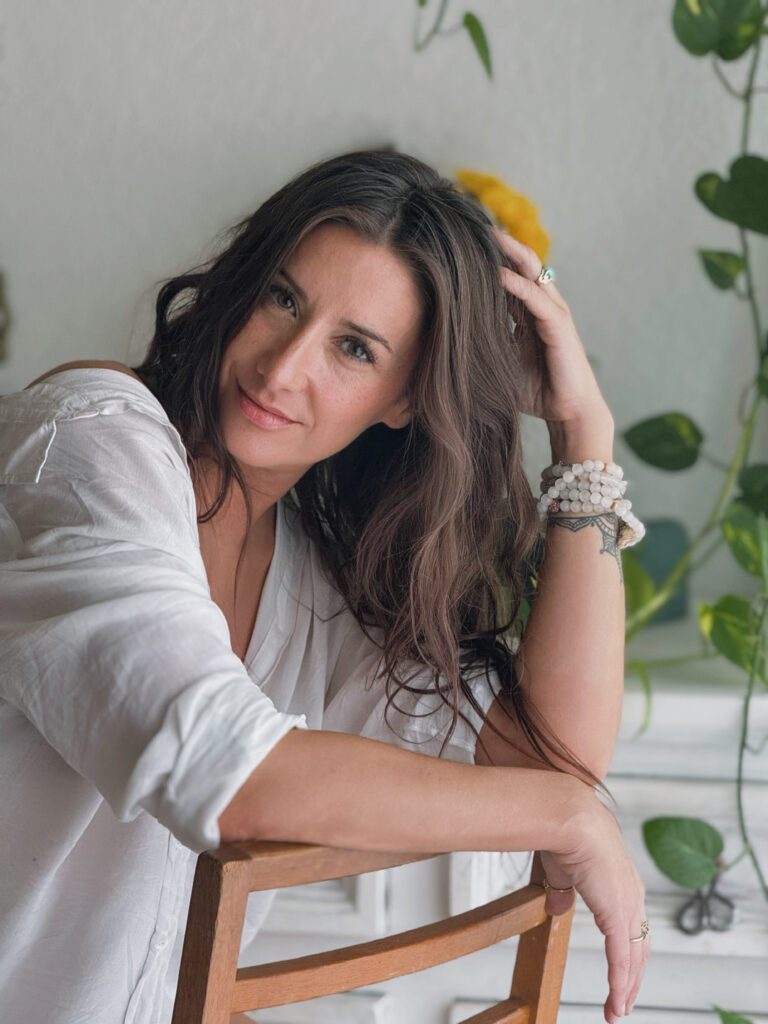 Relaxed Natalie sitting in a white dress.