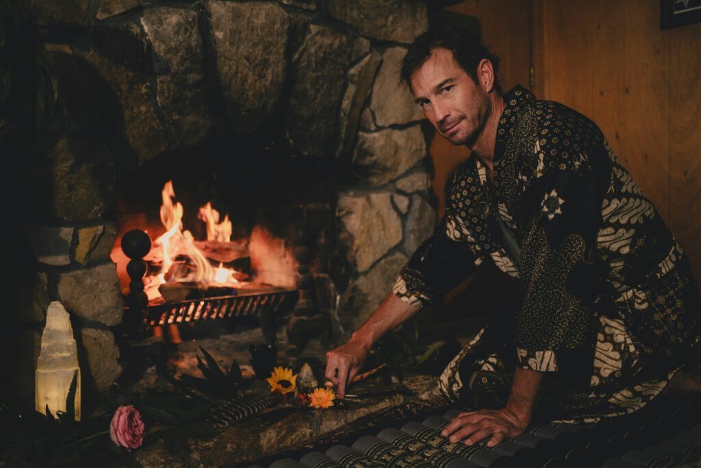 Sebastian laying flowers in front of a fire