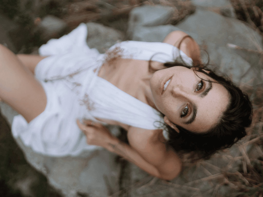 Naiyana Raine in a white dress looking up