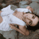 Naiyana Raine in a white dress looking up