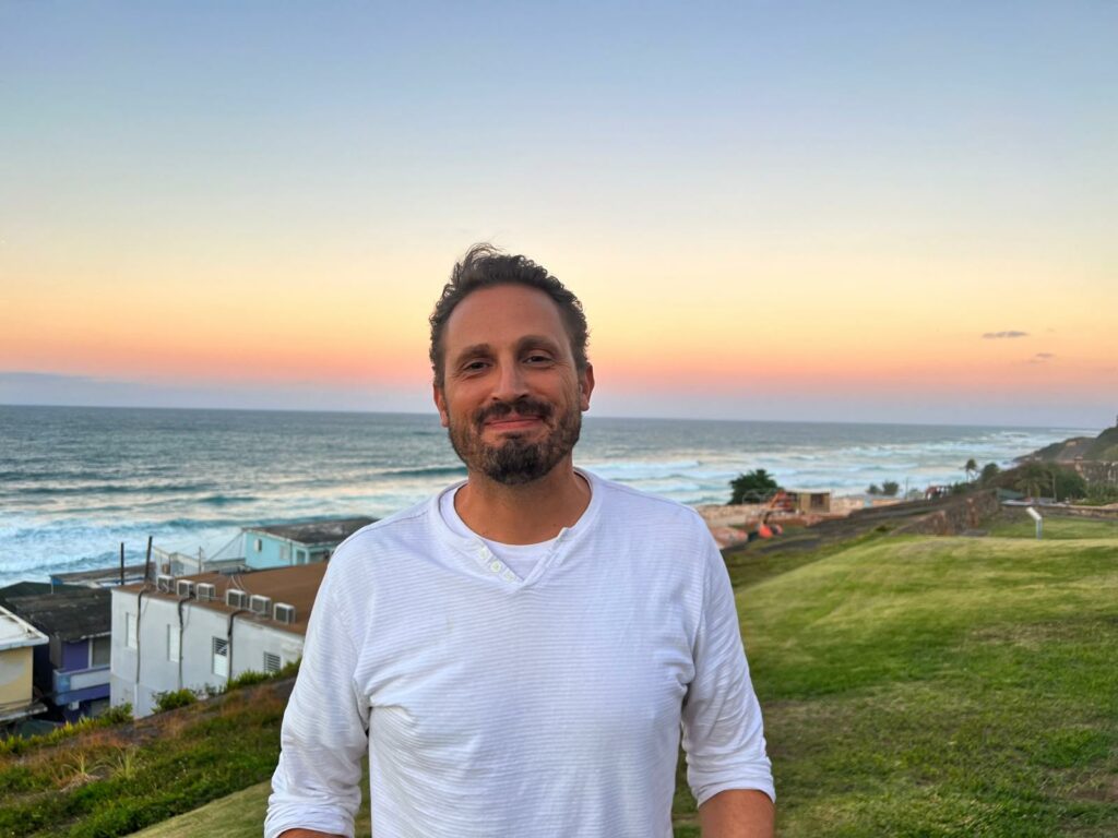 Daka Keith by the seaside standing on a hilltop.