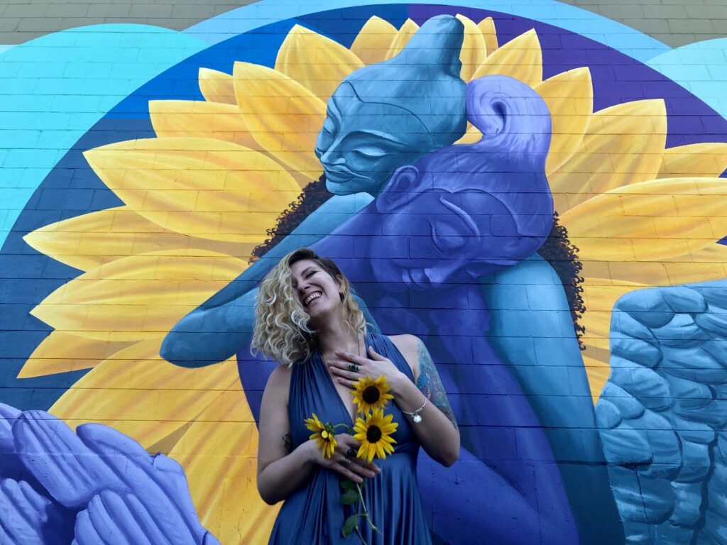 Yello-blue painted wall with Seriph in the front holding sunflowers.
