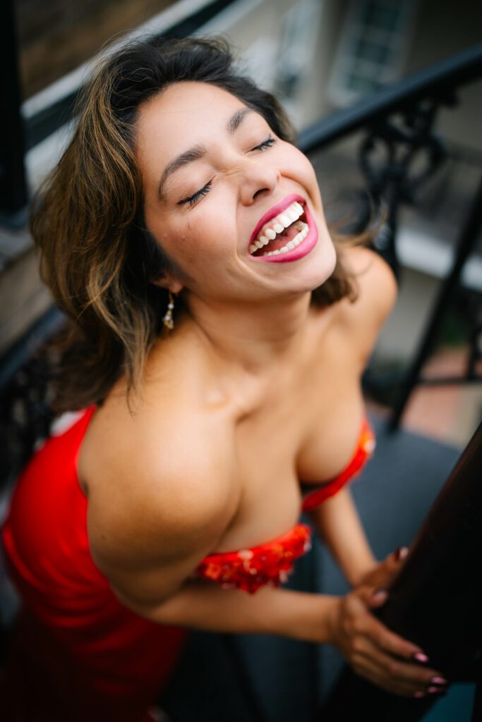 Mayra in a red dress that exposes her shoulders.