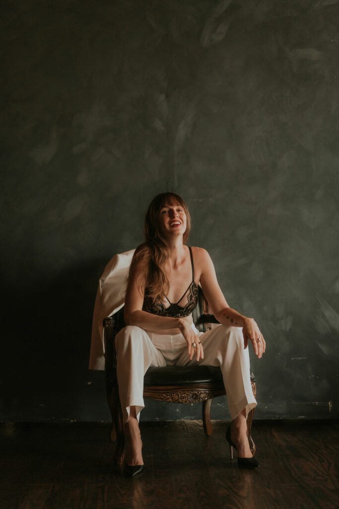 Samantha sitting on a chair and laughing.