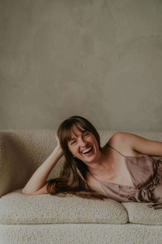 Big warm smile, lying down on the couch.