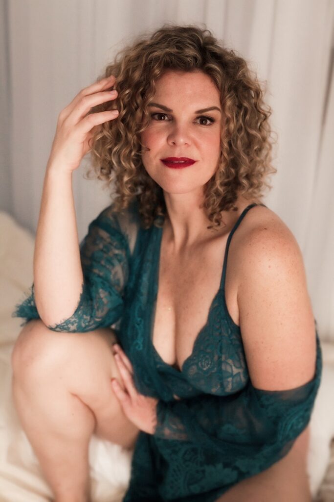 Wearing a green lingerie-like dress that exposes one shoulder.