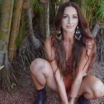 Dr Seva squatting in a tropical forest.