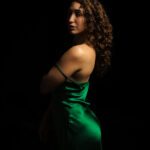 Dark background. Khyla in the front in a green velvet dress.