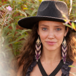 Close-up of Seraphina with a top hat and colorful earrings.
