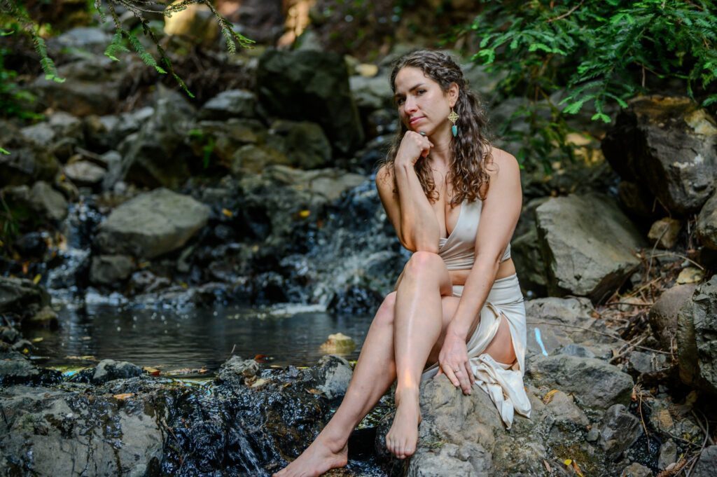 Contemplating Dr Rose sitting on a rock in the nature.