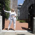 Metal gates in the city. cassy at the entrance in white.
