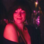 Warm smile, red light, dark room.
