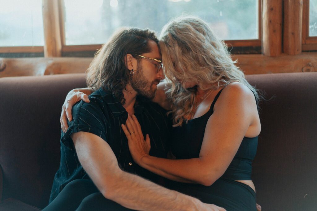 A lady and Sam cuddling on the couch.