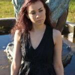 Viola Swan sitting in front of a fountain.