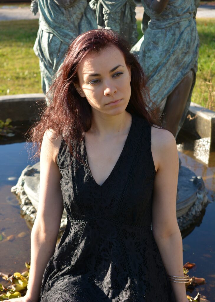 Viola Swan sitting in front of a fountain.