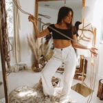 Jaqueline standing in her studio while holding a rope in her hands.