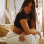 Sensual Shibari Artist sitting on the bed looking a the camera with a serious professional expression.