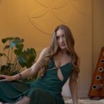 Savannah sitting on a sheepskin in a green dress.