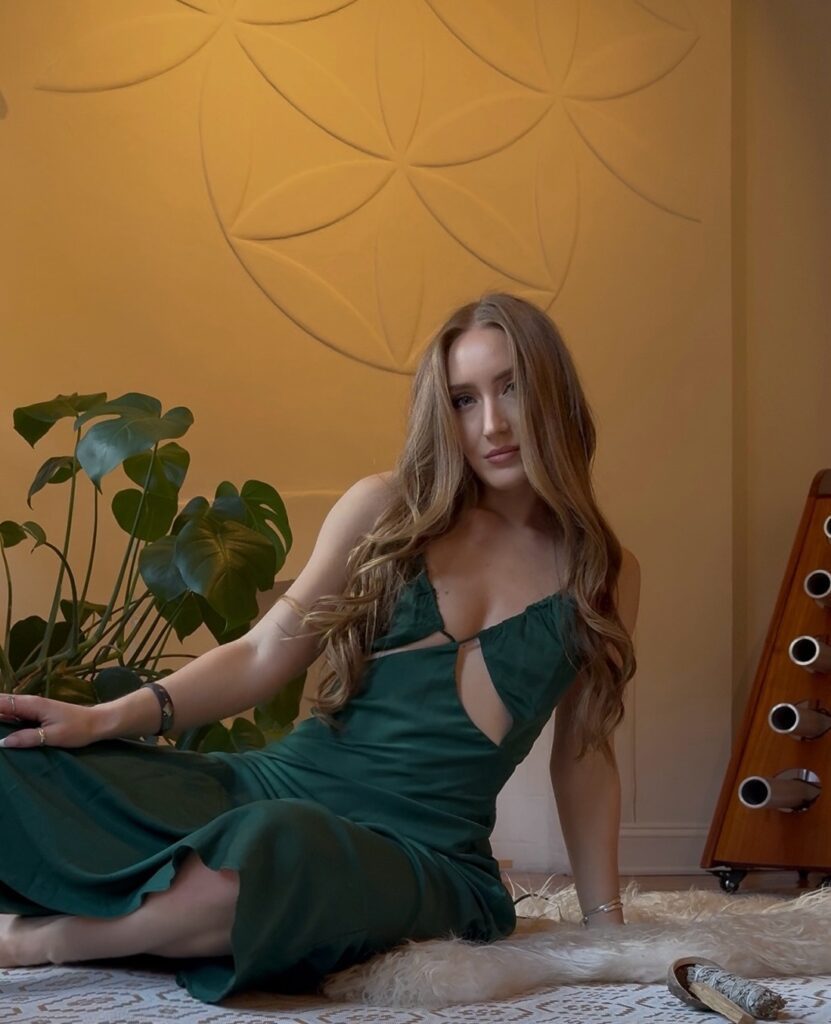 Savannah sitting on a sheepskin in a green dress.
