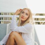 Savannah in a white blouse sitting and contemplating.