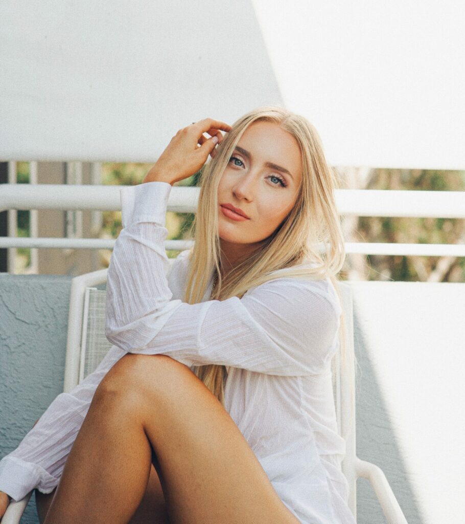 Savannah in a white blouse sitting and contemplating.