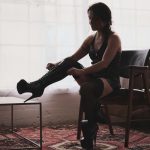 Kalika tying up her black platform shoes.