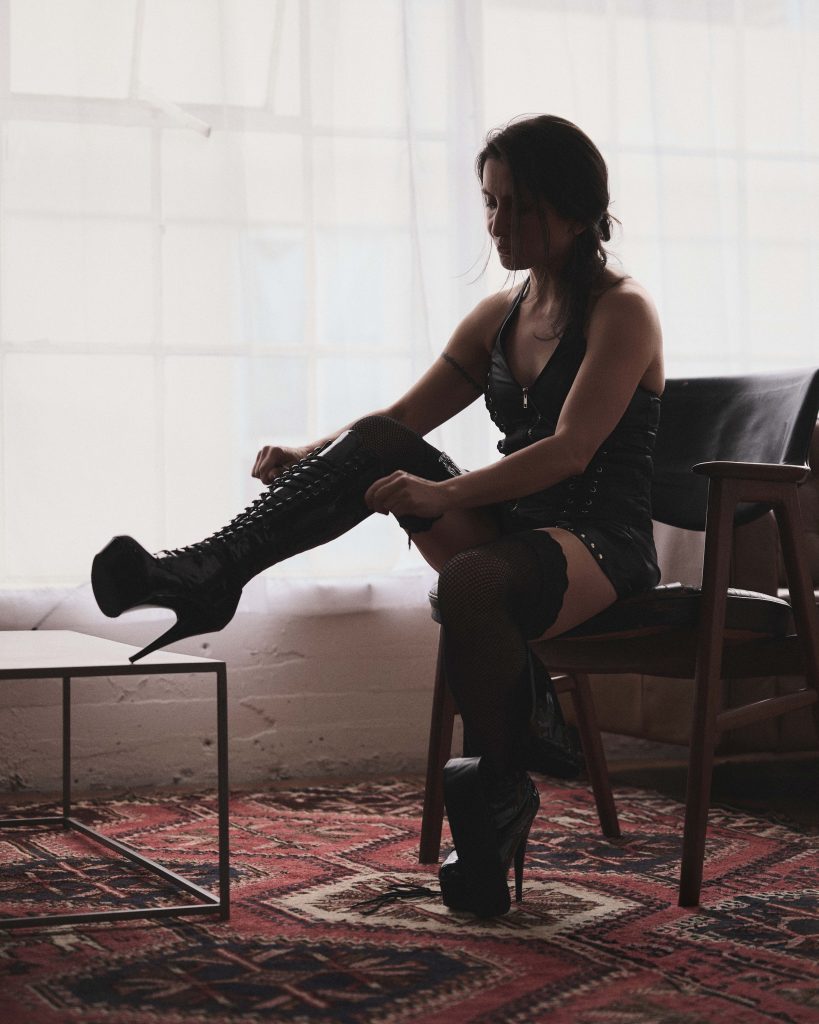 Kalika tying up her black platform shoes.