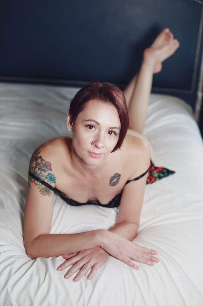 Aria Moon resting on a bed on her belly.