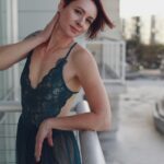 Aria Moon on the balcony in an airy green dress.