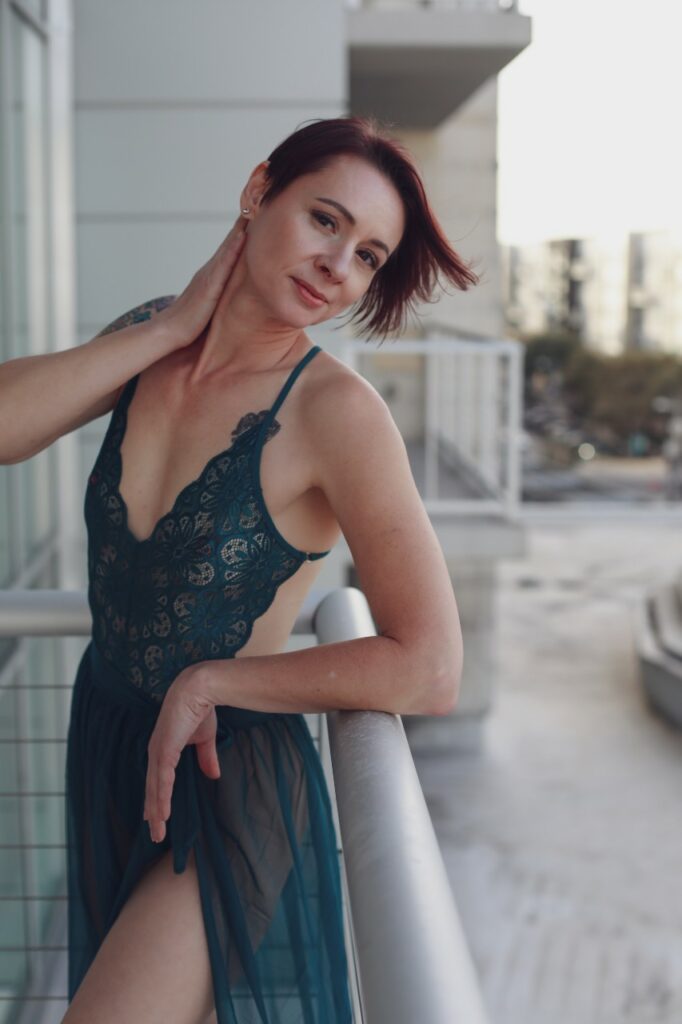 Aria Moon on the balcony in an airy green dress.