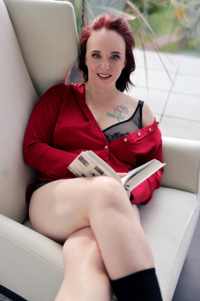 Tigress Lily in a cozy armchair reading a book.