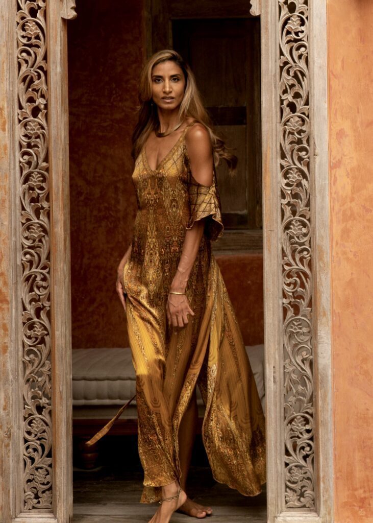 Beautiful patterned doorway surronding Ruby Lovelight who is wearing and elegant long golden dress.