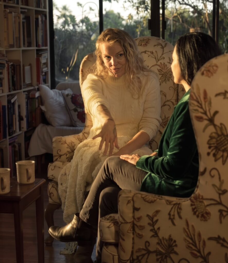 Kat and her client sitting in armchairs and interacting.