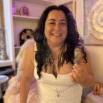 Wide smile, white dress.