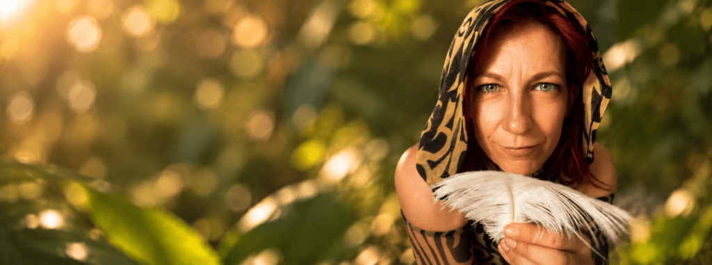 Kailani with a leopard patterned hood holding a feather.