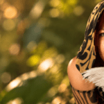 Kailani with a leopard patterned hood holding a feather.
