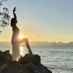 Sunset by the sea. Elle stretching in the front.