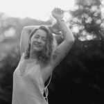 Black&white shot of Kay Love holding her hands above her head.
