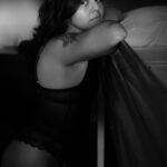 Black&white shot of Amada leaning against a high bed.