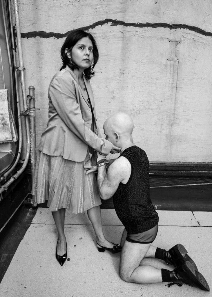 Male client kneeling in front of Mistress Amada.