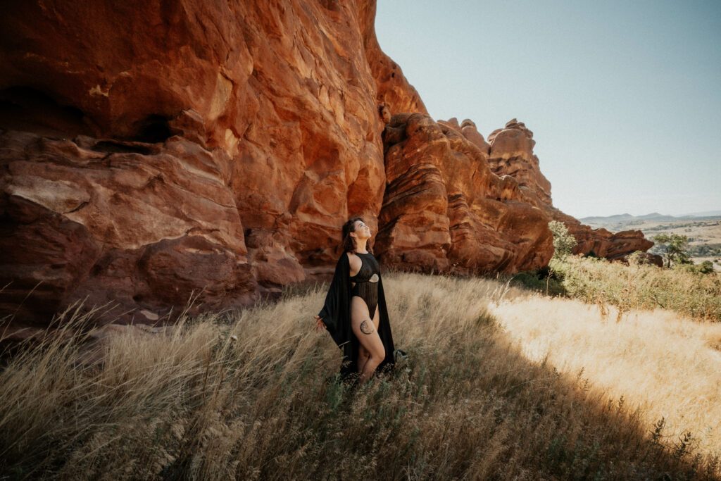 Nature shot of Kay Love next to a big cliff.