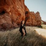 Nature shot of Kay Love next to a big cliff.