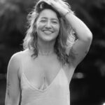 Kay Love in white dress with a warm smile.