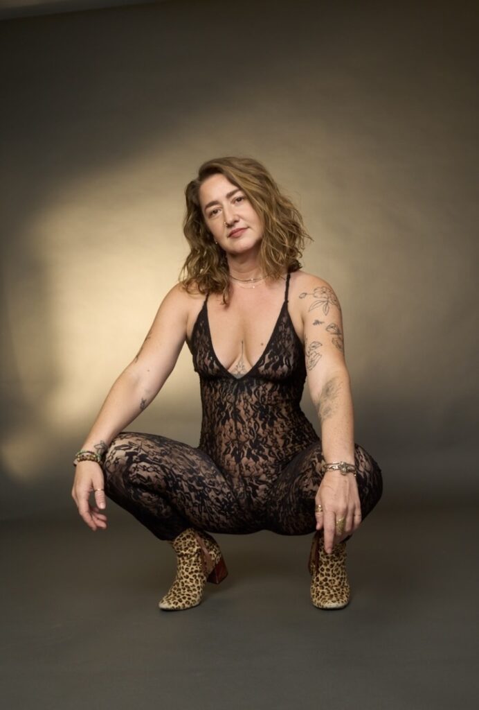 Kay Love squatting with her hands on her knees.